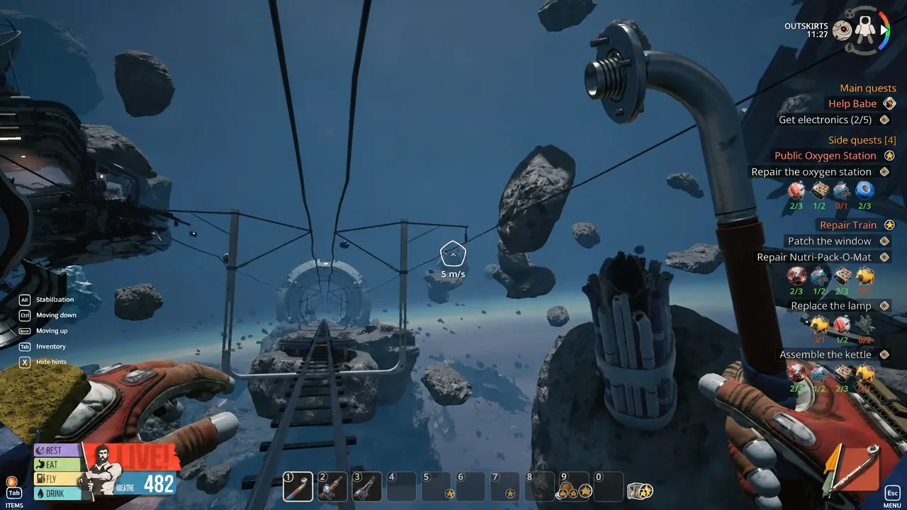 Shoes hanging from a cable in space with the Outskirts train tracks running underneath