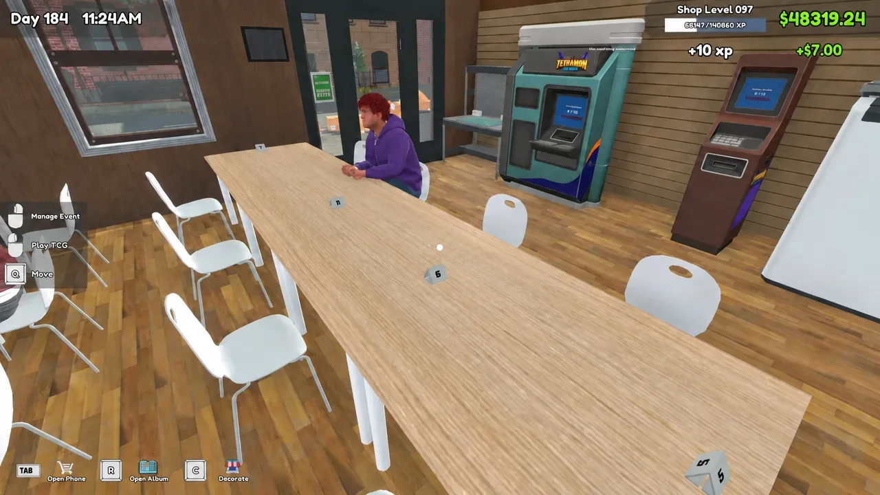 A customer seated at a numbered play table with the Manage Event and Play TCG prompts visible