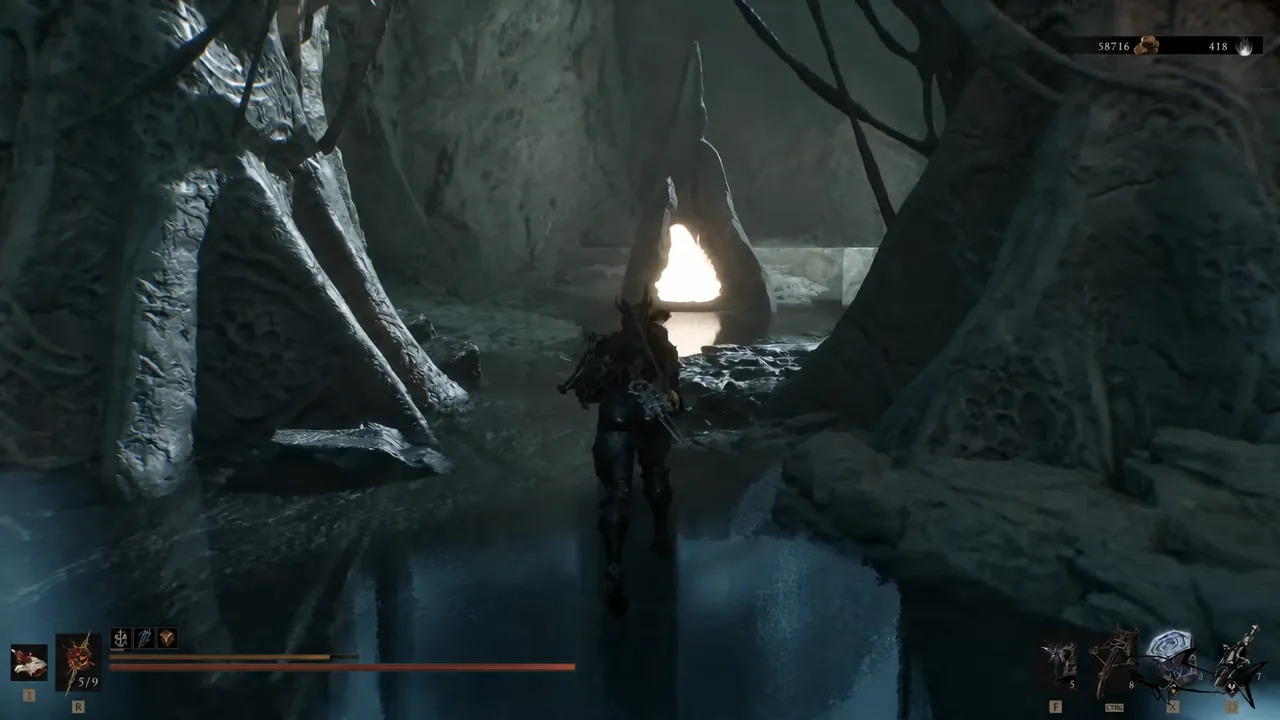 Player wading through a dark flooded cave toward a bright opening ahead