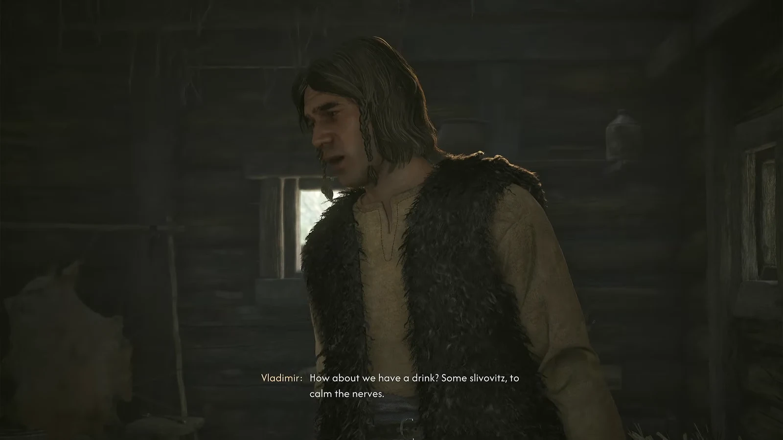 Vladimir talking to Coen in a dim cabin and offering a drink of slivovitz
