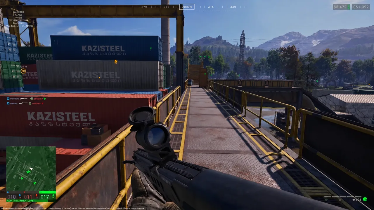 First-person gameplay screen shows a scoped rifle while moving along an industrial catwalk beside stacked shipping…