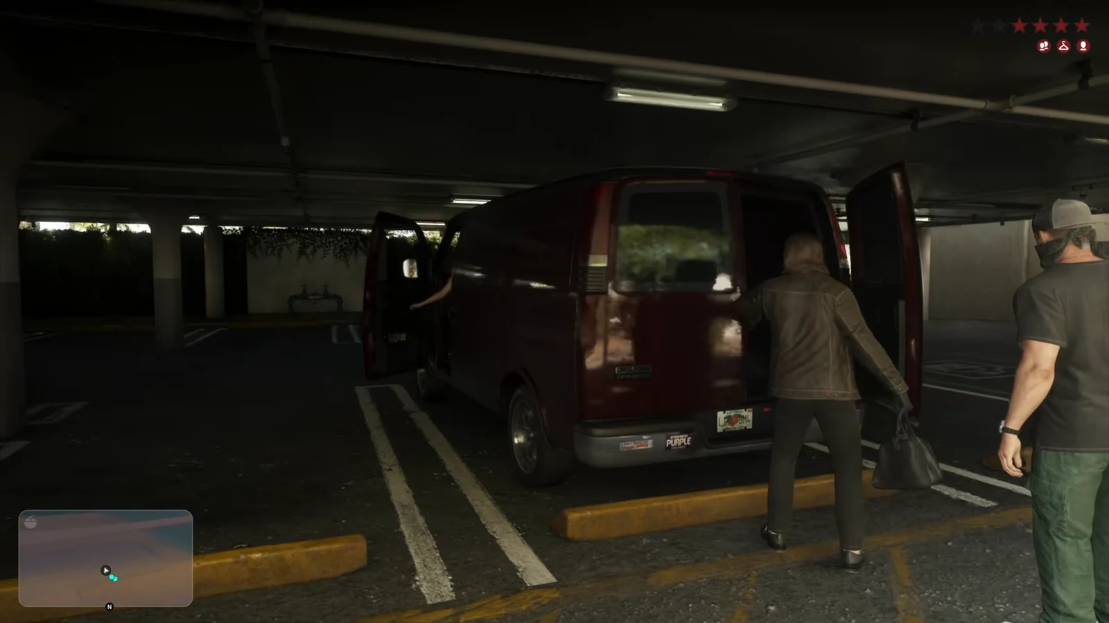 Maroon van with rear doors open as the crew loads bags inside a parking garage