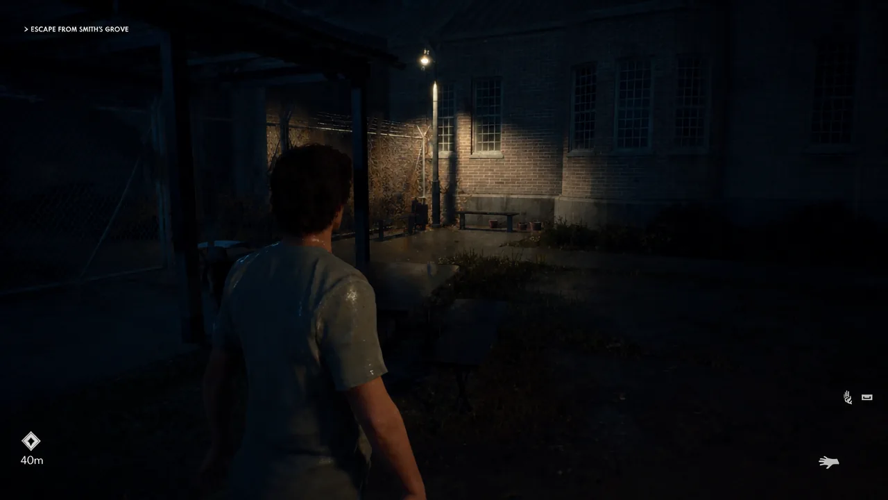 Michael moving back through the dark, rain-soaked courtyard toward the corner with the benches