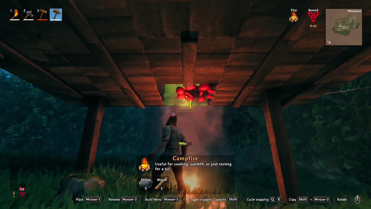 Build menu with the Campfire selected and its placement outline shown under a wooden shelter