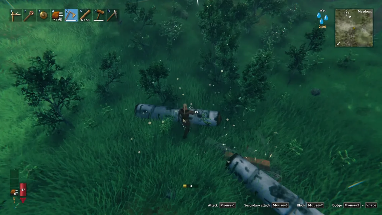 Player cutting a felled birch log into smaller segments with the axe hotbar slot highlighted