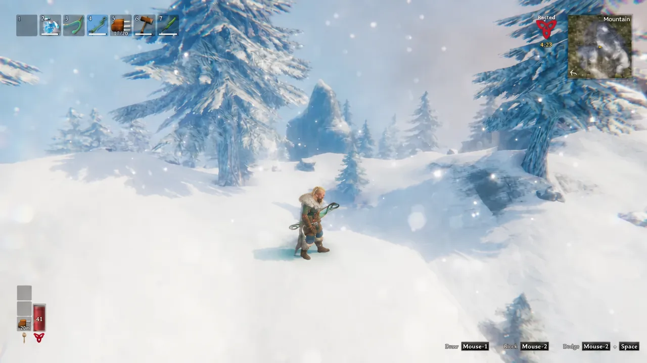 Climbing a snowy Valheim mountain slope during a storm with the bow selected on the hotbar