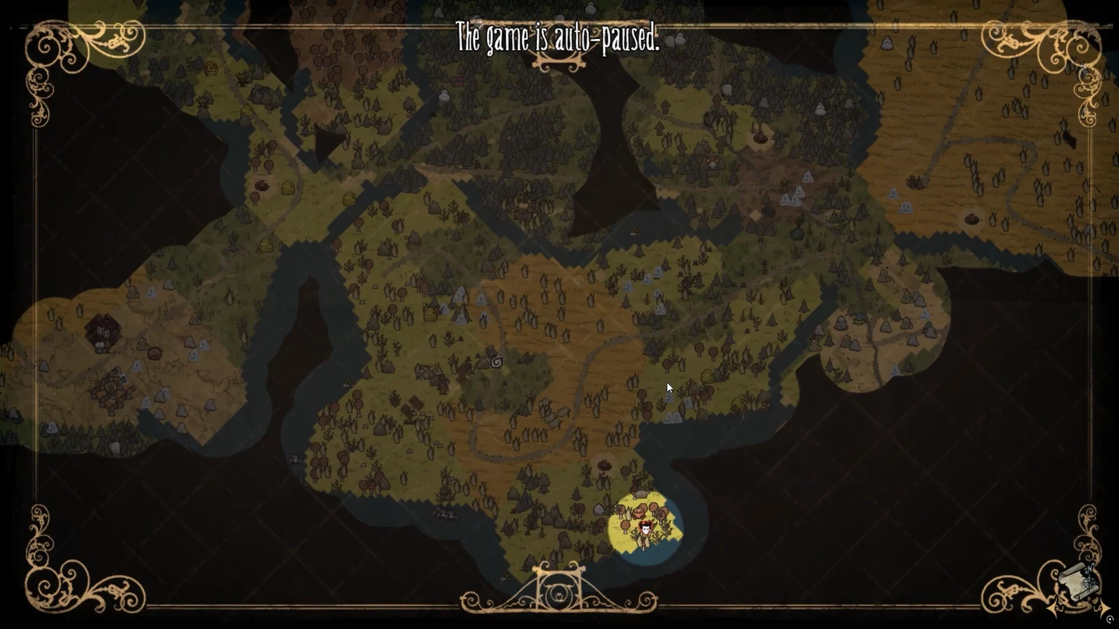 The auto-paused world map showing explored terrain and the player marker in the southeast