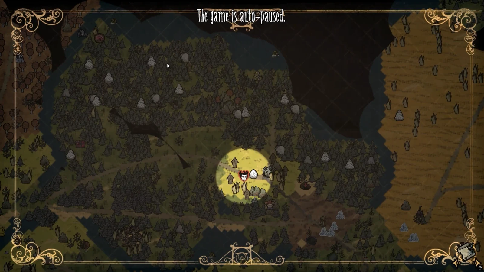 World map view with the character standing near grass tufts and a rock while the game is auto-paused
