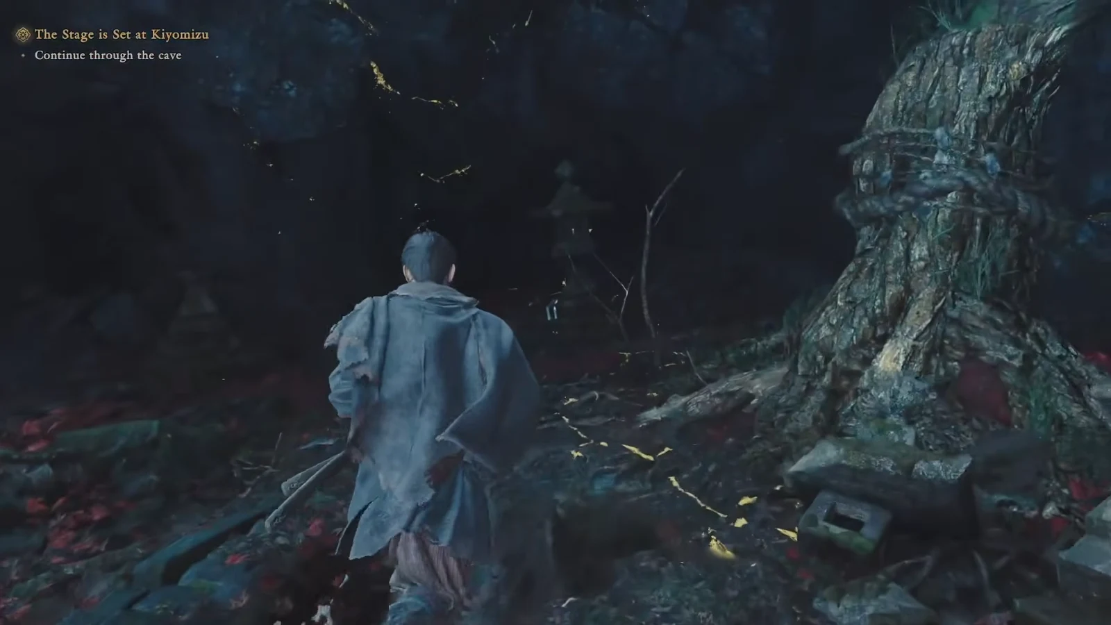 Musashi walking through the dark cavern with the objective prompt to continue through the cave