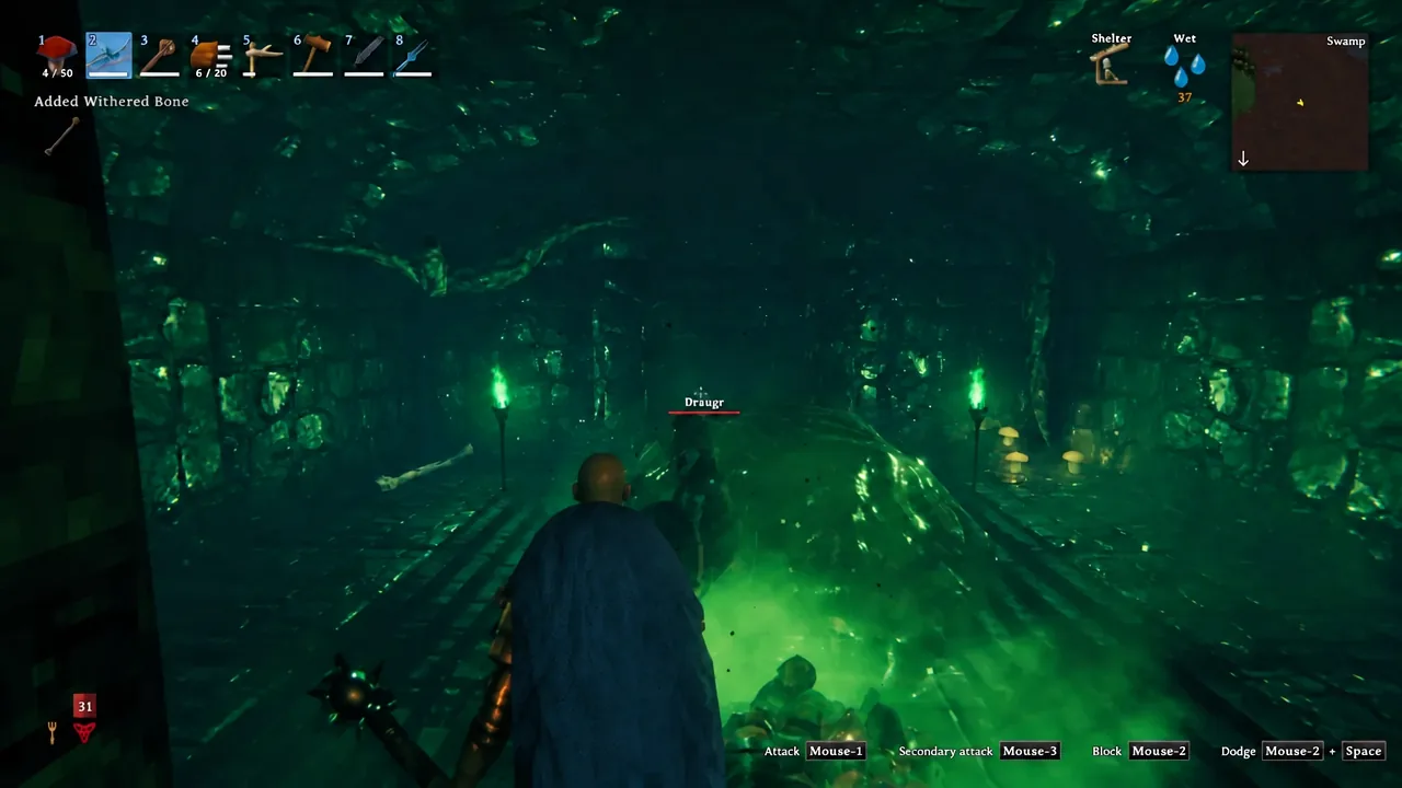 Player fighting a Draugr in a Valheim crypt chamber with the attack prompt on screen