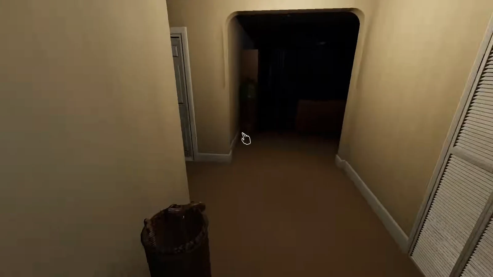 Player approaching a dark hallway doorway with the interaction cursor visible