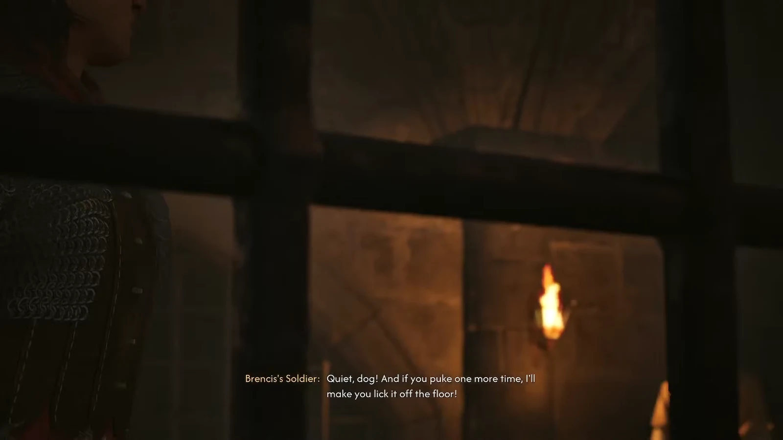 Brencis's Soldier reacting angrily in the torchlit cell block after Coen claims the prisoner is sick
