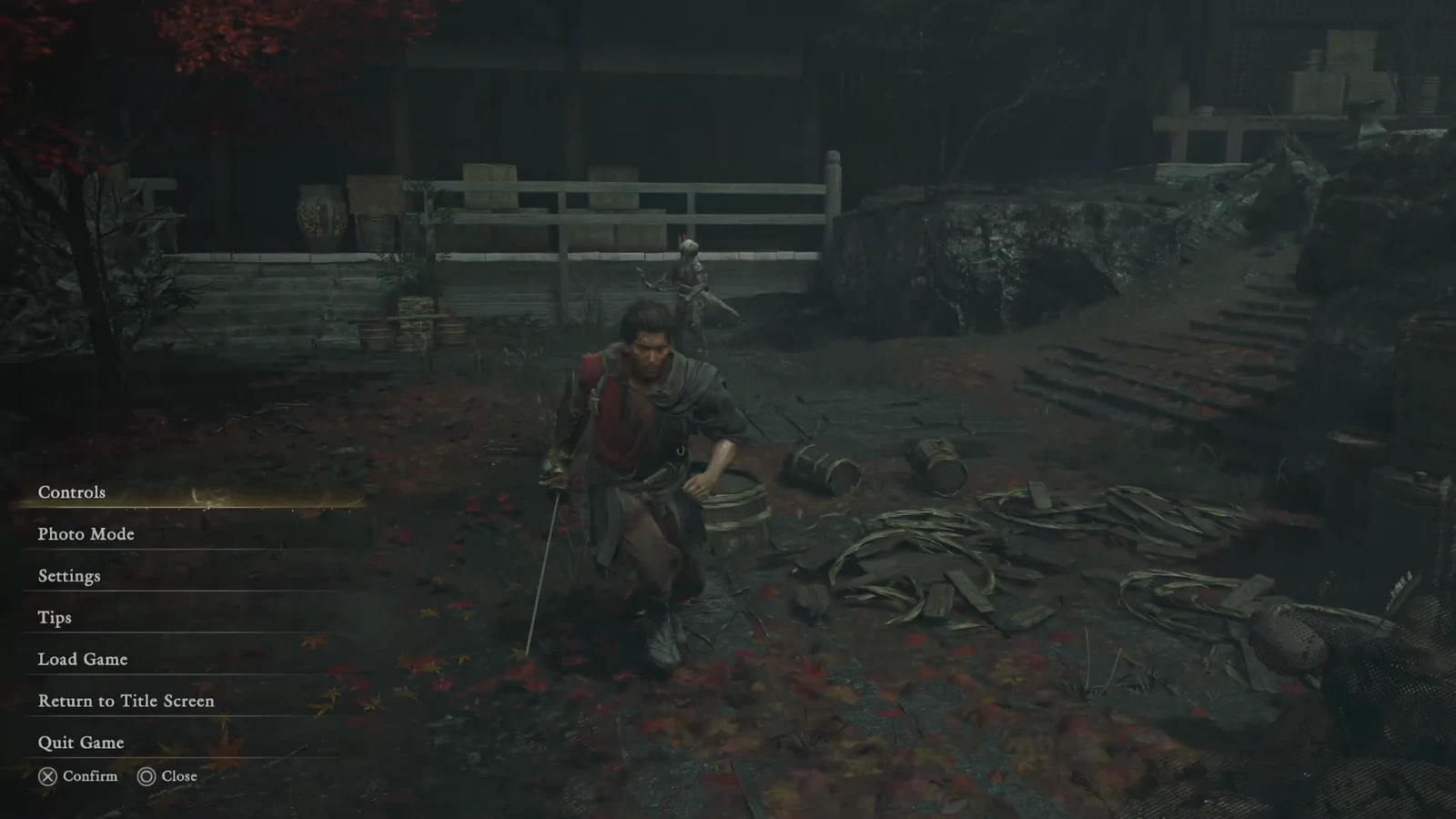 The paused menu listing Controls, Photo Mode, Settings and other options in a night-time courtyard