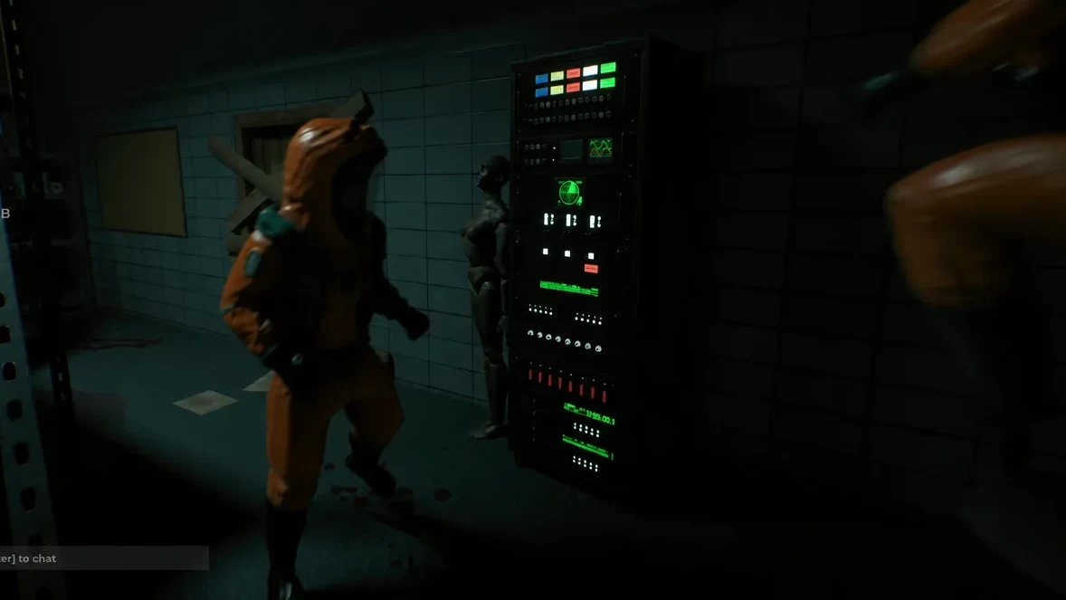 Two crew members standing beside a lit control panel in a dark hotel interior