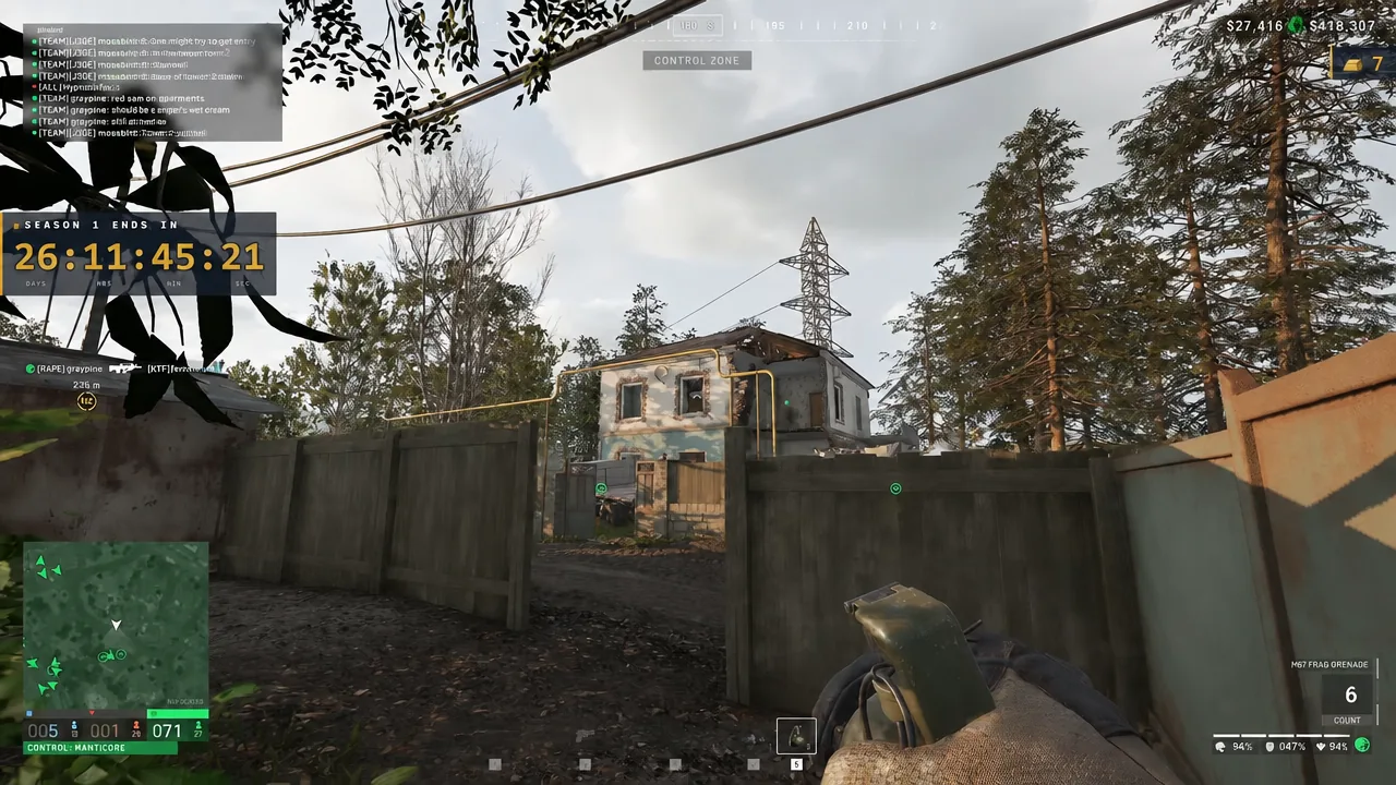 M67 Frag Grenade selected on the HUD while aiming over a fence toward an enemy-held house