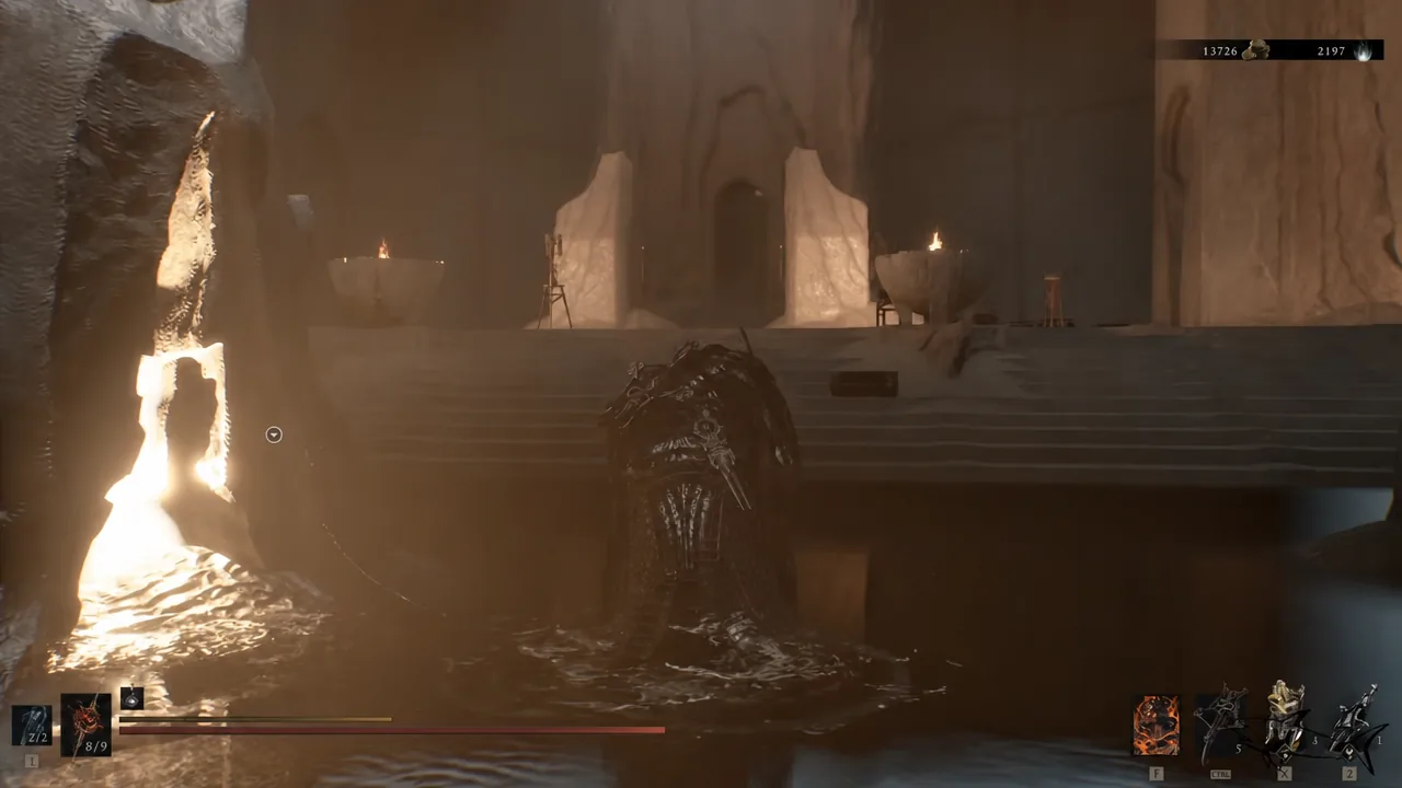 Player wades through shallow water toward a temple staircase with an objective marker on the left