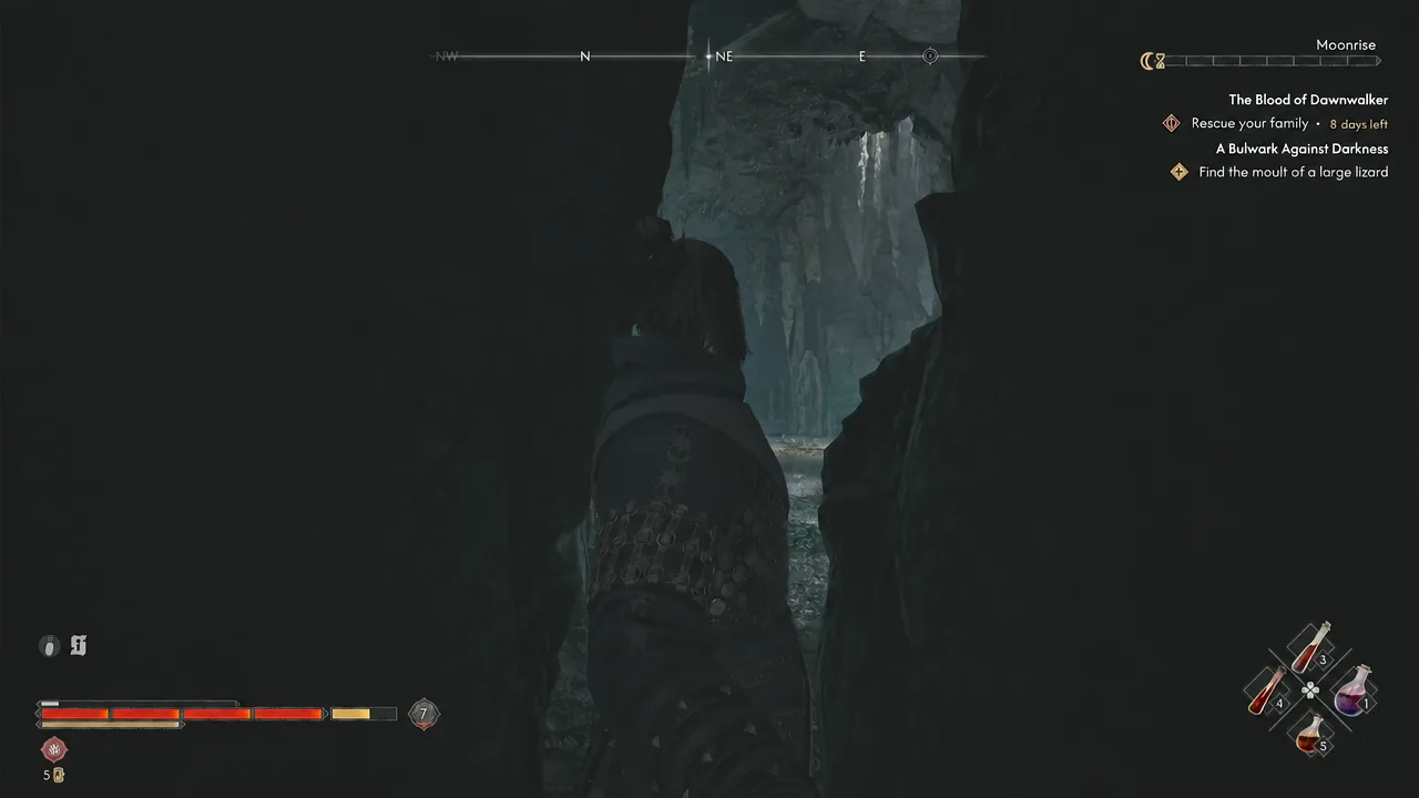 Character squeezing through a tight rock passage deeper into the cave