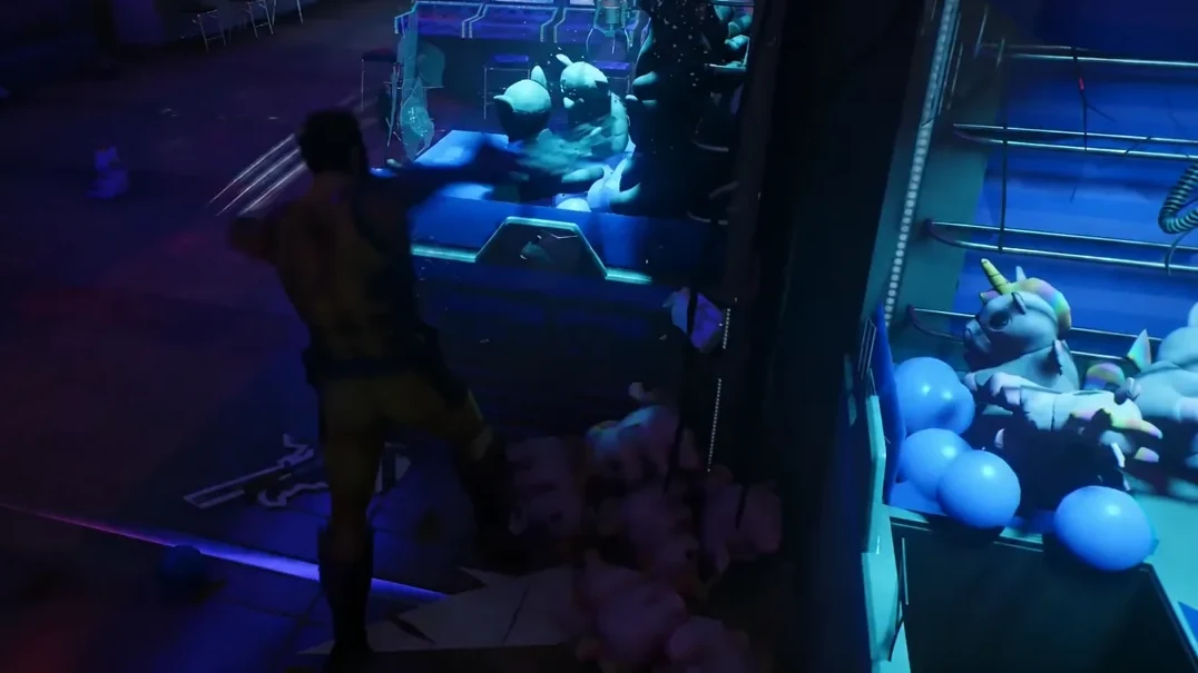 Logan tearing into a plush-toy claw machine on the arcade floor
