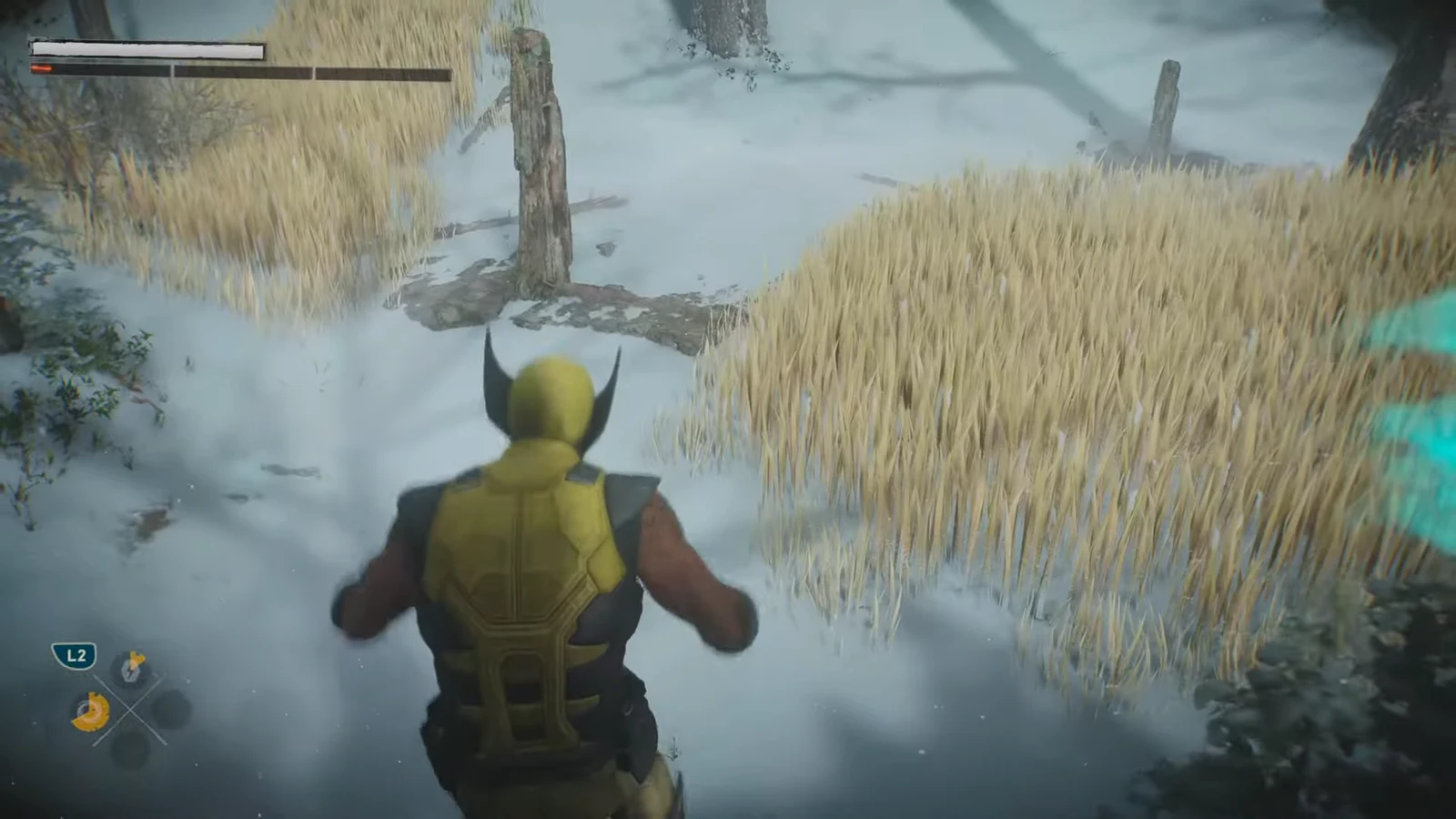 Wolverine moves through tall grass in a snowy field with the L2 prompt shown in the HUD