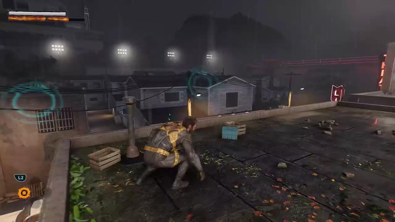 Logan crouched on a rooftop in the fake town with the L2 prompt showing