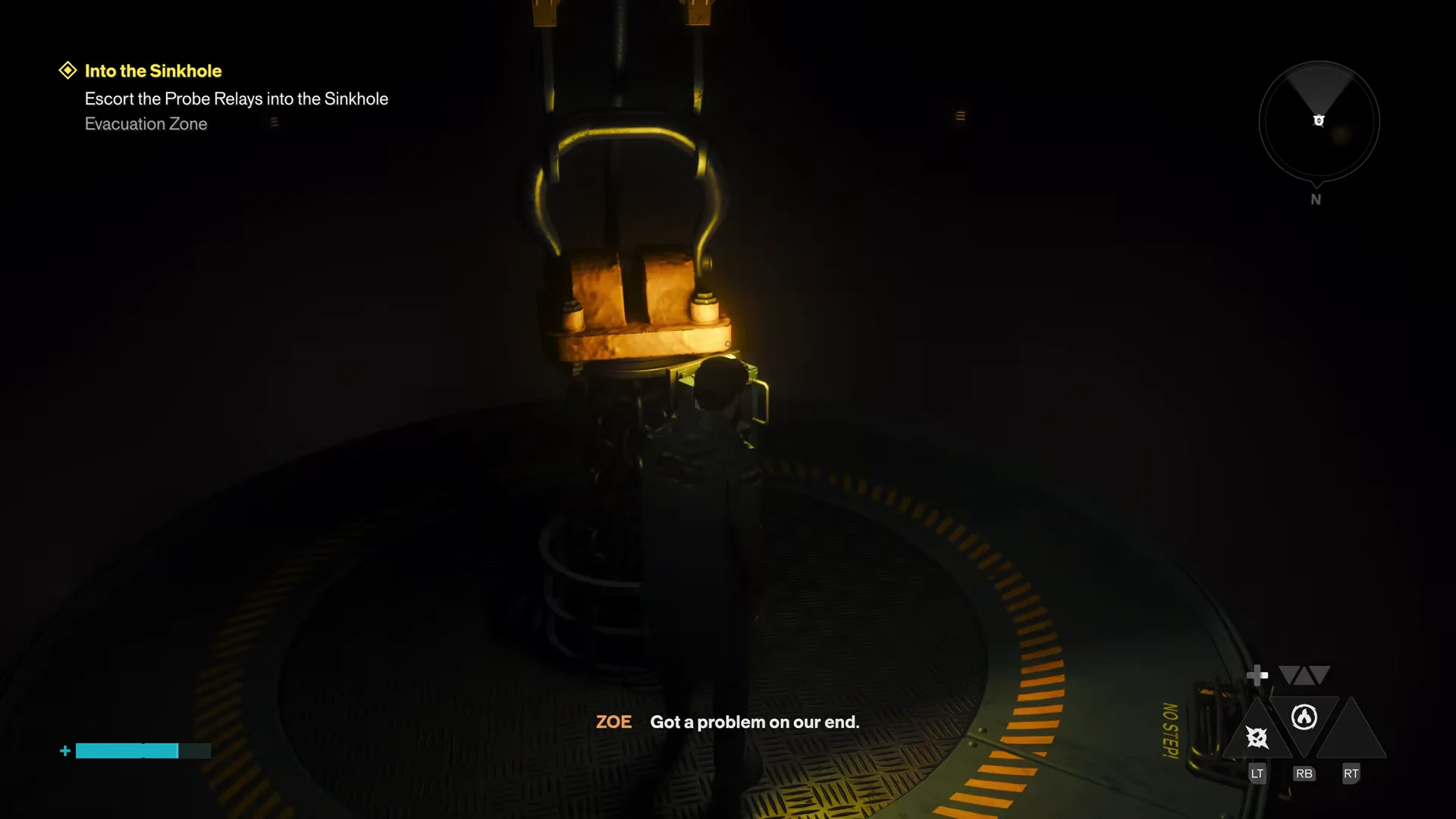 Dylan stands on the round platform beneath the diving bell as it lowers into the shaft