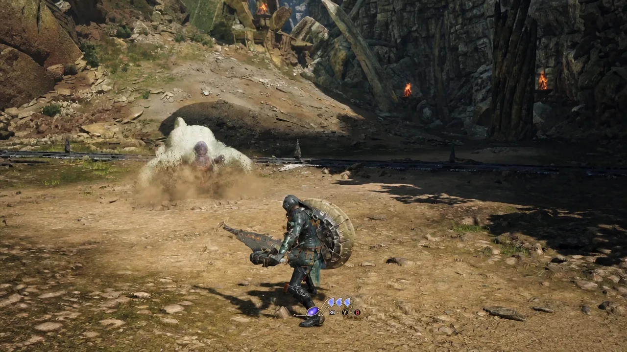 Armored hunter squaring up against a burrowing monster with combat prompts shown on screen