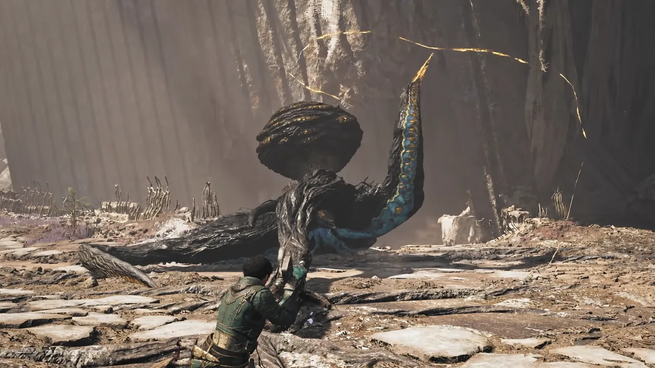 Hunter aiming a Light Bowgun at a large tentacled monster inside a cavern