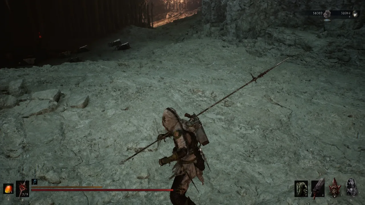 Player carrying a long spear across rocky ground near the cave checkpoint