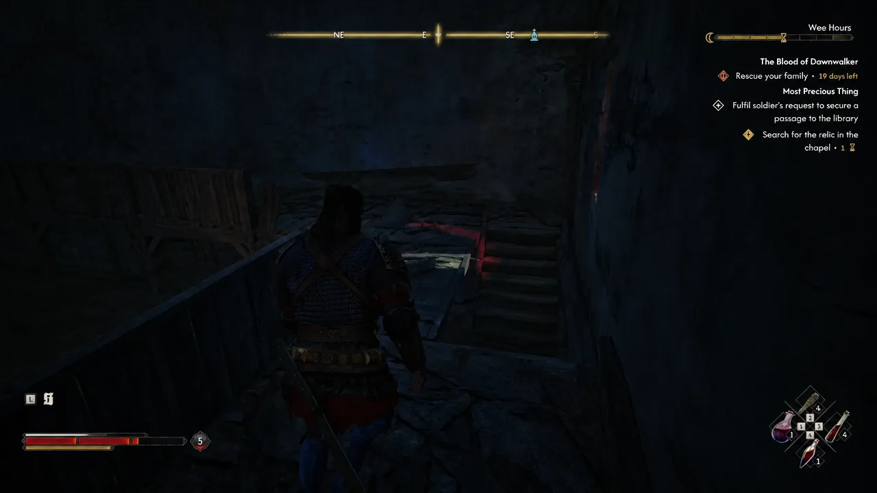 Coen moving through a dark monastery passage with the chapel relic objective still active