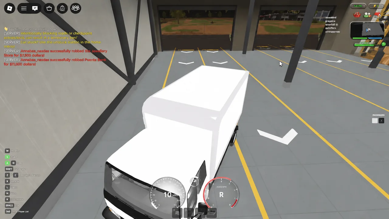 A white delivery truck being reversed into a marked garage bay with the HUD showing gear R.