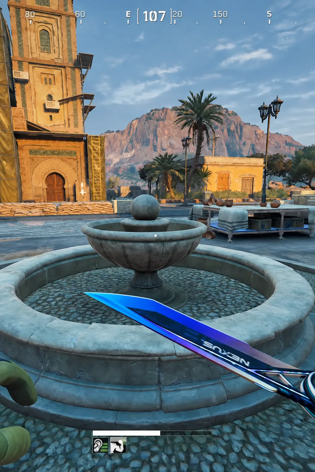 View of the stone courtyard fountain in Aminya Village with the compass and health bar on screen