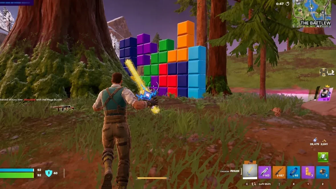 Player using a pickaxe to break a colorful block structure during a Fortnite match