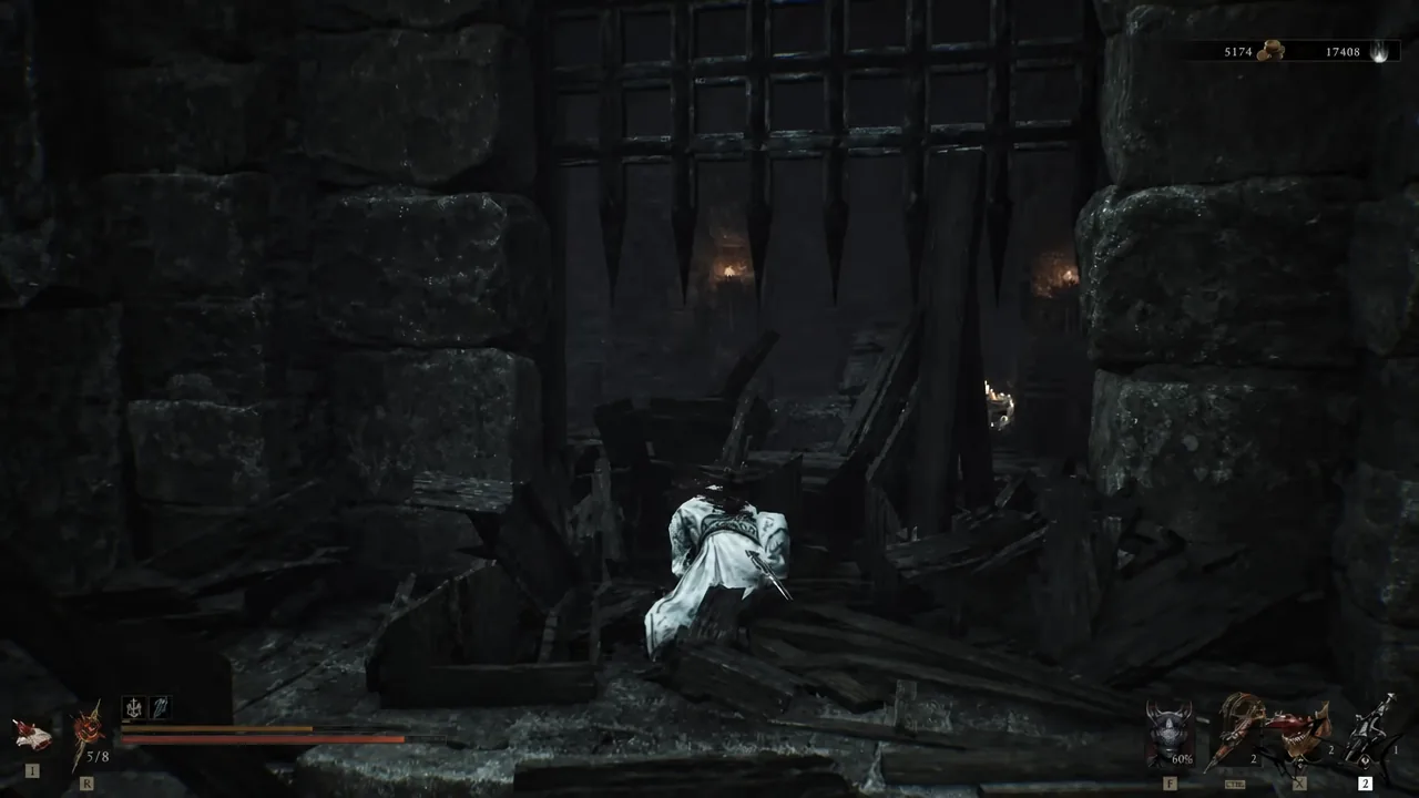 Ruined debris-filled passage leading to a closed portcullis near the offering chest building