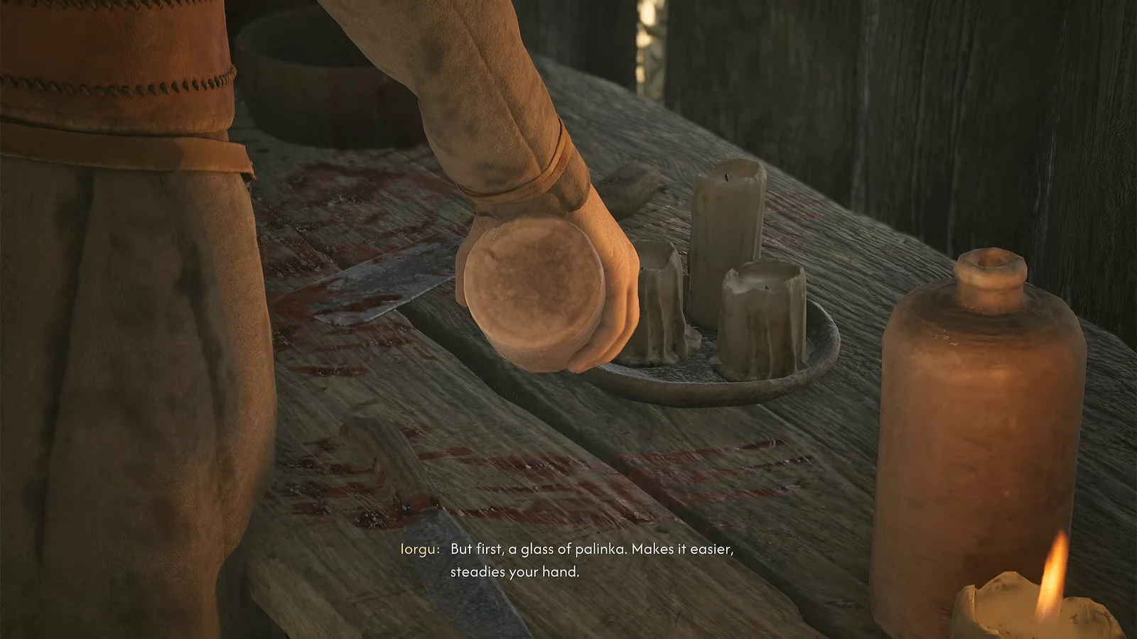 A glass of palinka held over a bloodstained workbench before the slaughter
