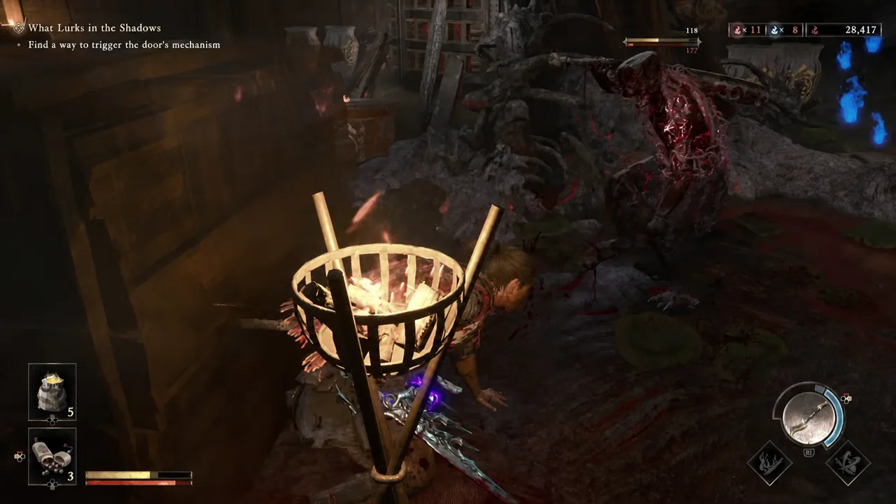 Musashi standing beside a lit brazier while hunting for the door mechanism in a darkened area