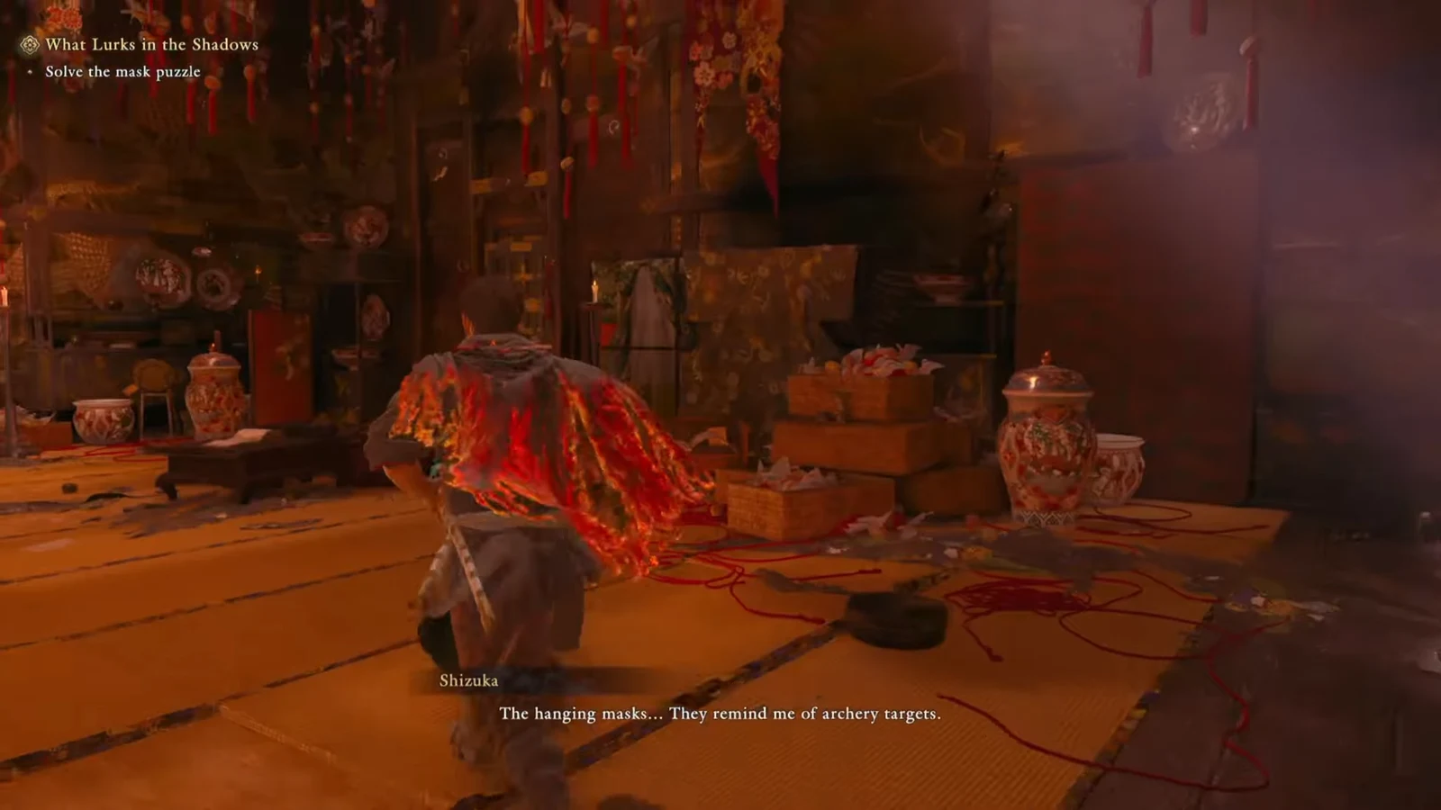 A companion studies the masks strung across the room and compares them to archery targets
