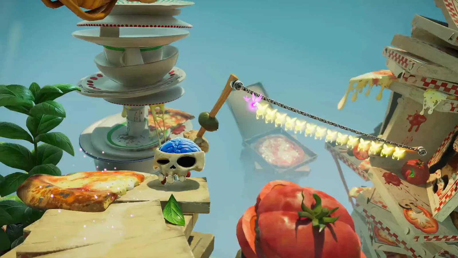 Rayman navigates a whimsical food-themed platforming area with giant teacups, pizza, tomatoes, and floating kitchen objects.