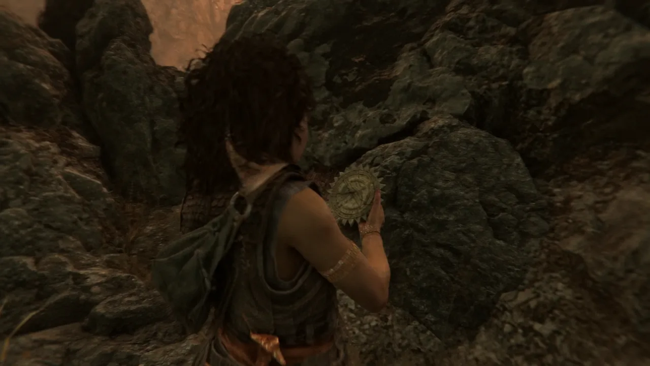 Sophia crouched in a narrow rock crevice picking up the circular Sun Dial relic