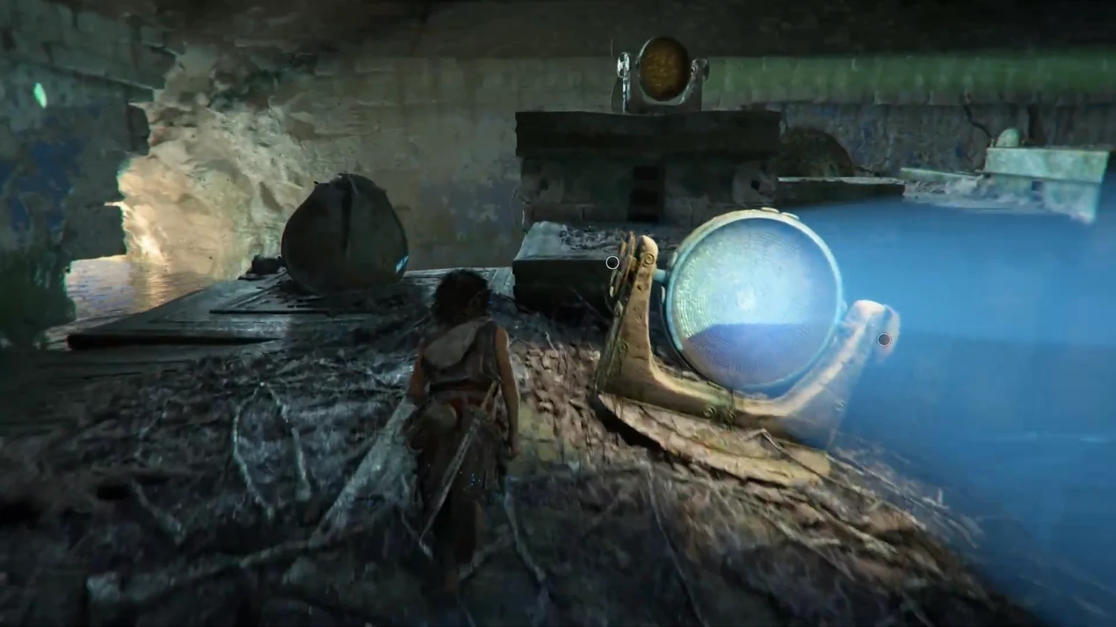Sophia aiming a beam at a glowing circular dial beside a pool of blue water in the ruin