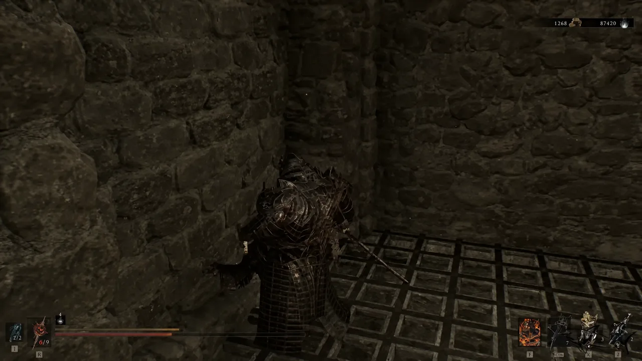 Player standing in front of a blank stone wall with a weapon selected in the bottom-right HUD