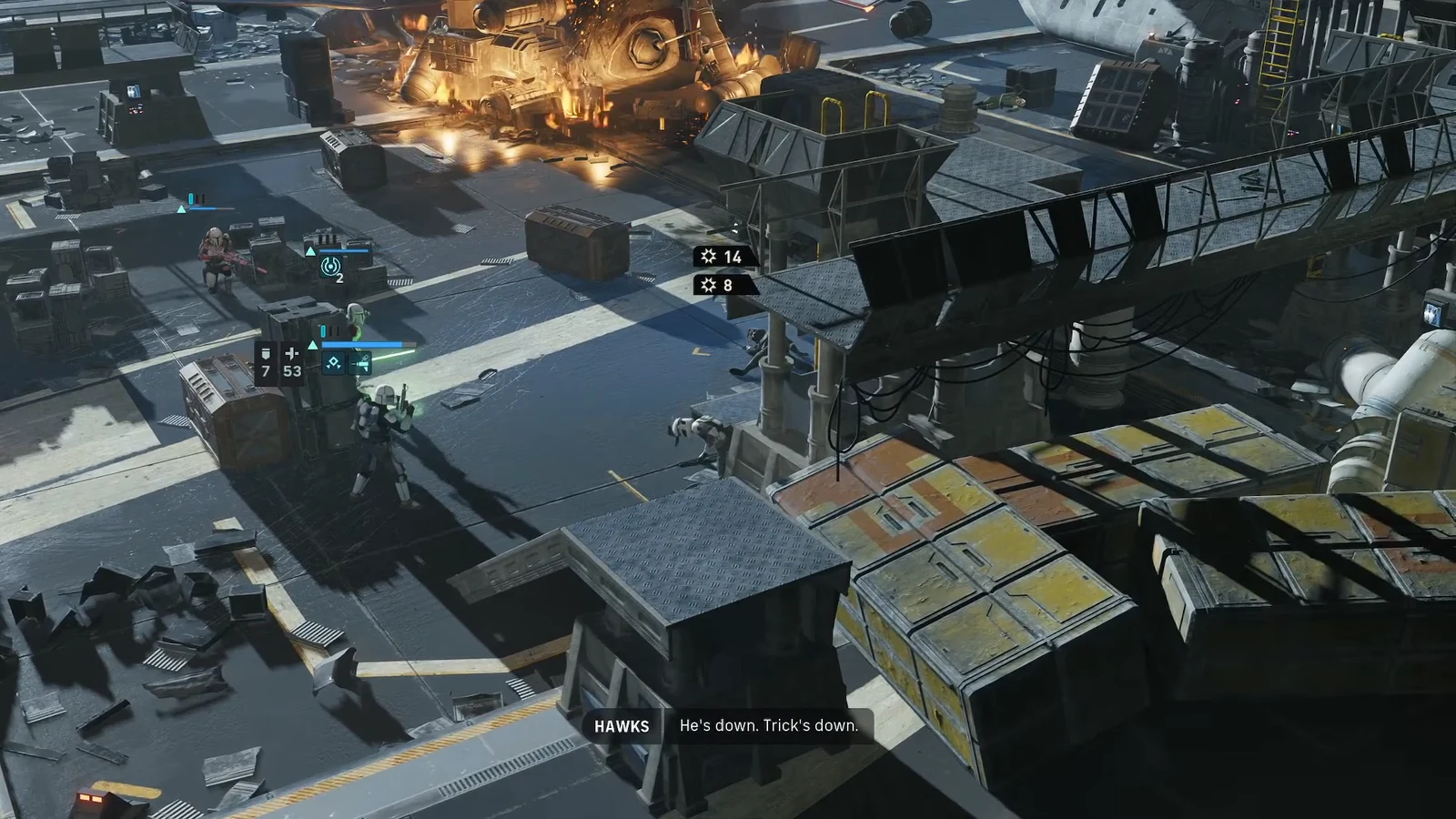 Squad members firing on the last enemies across an industrial battlefield with burning wreckage
