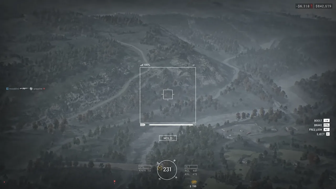 Drone HUD in flight with the central targeting reticle and HOLD prompt over open ground