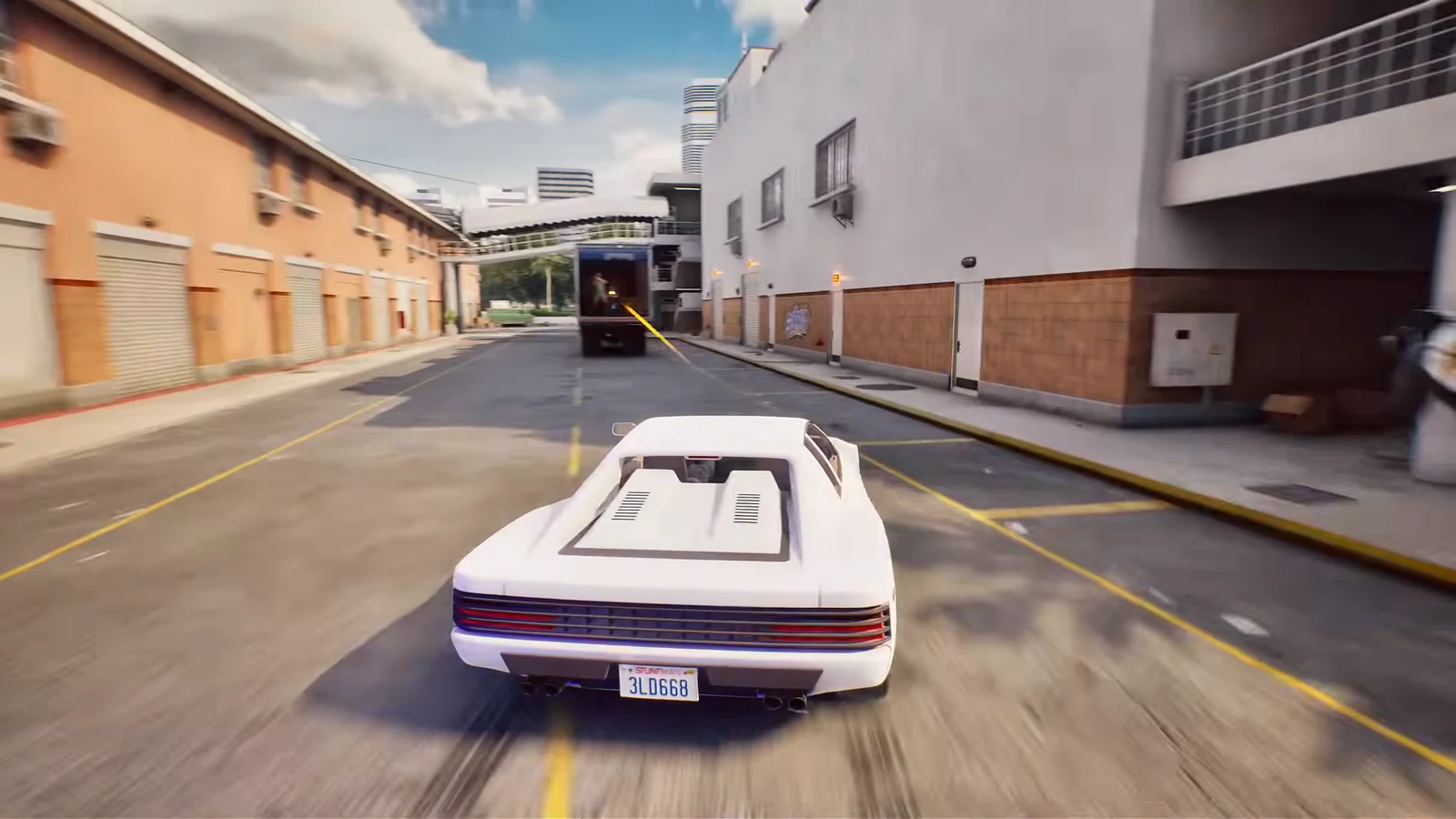White sports car chasing a marked truck down a city street during a stunt take