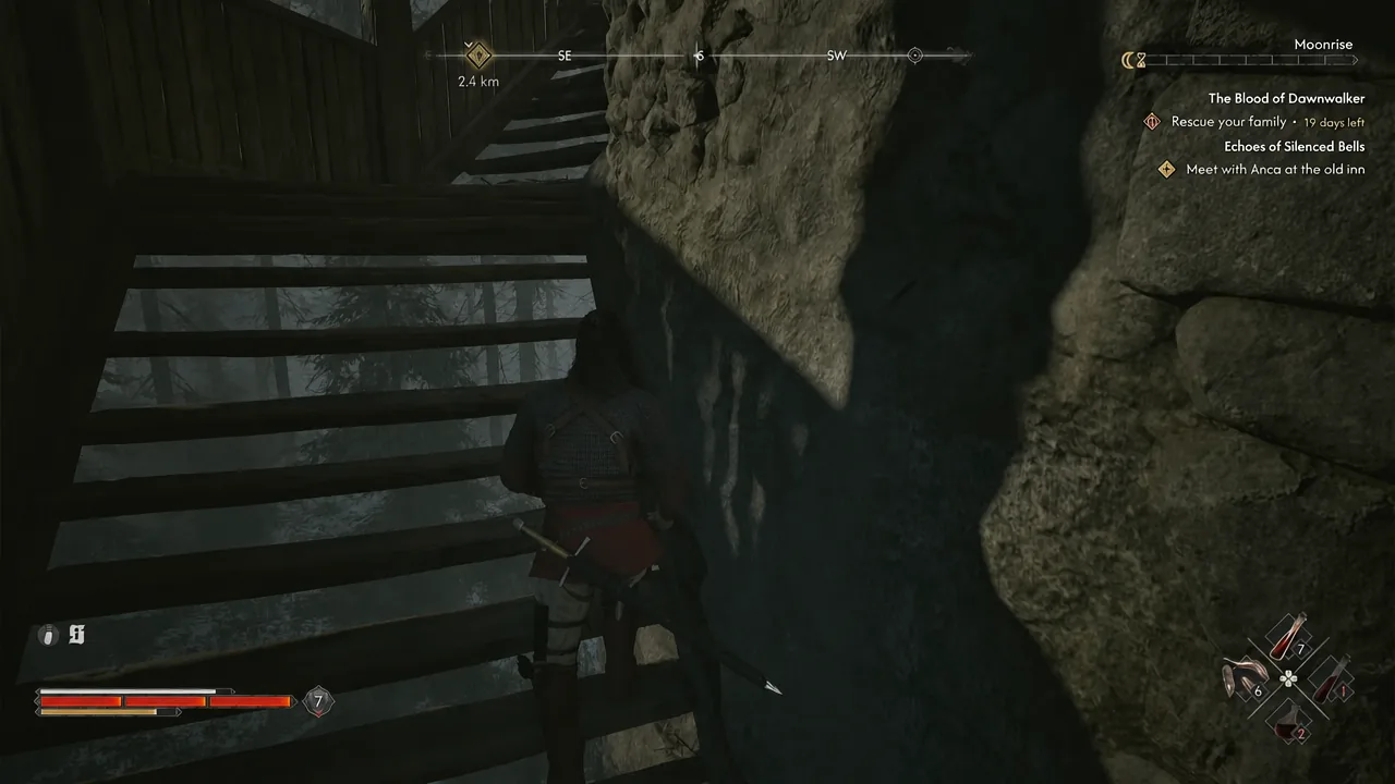 Coen climbing the narrow wooden staircase inside the tower beside a rock wall