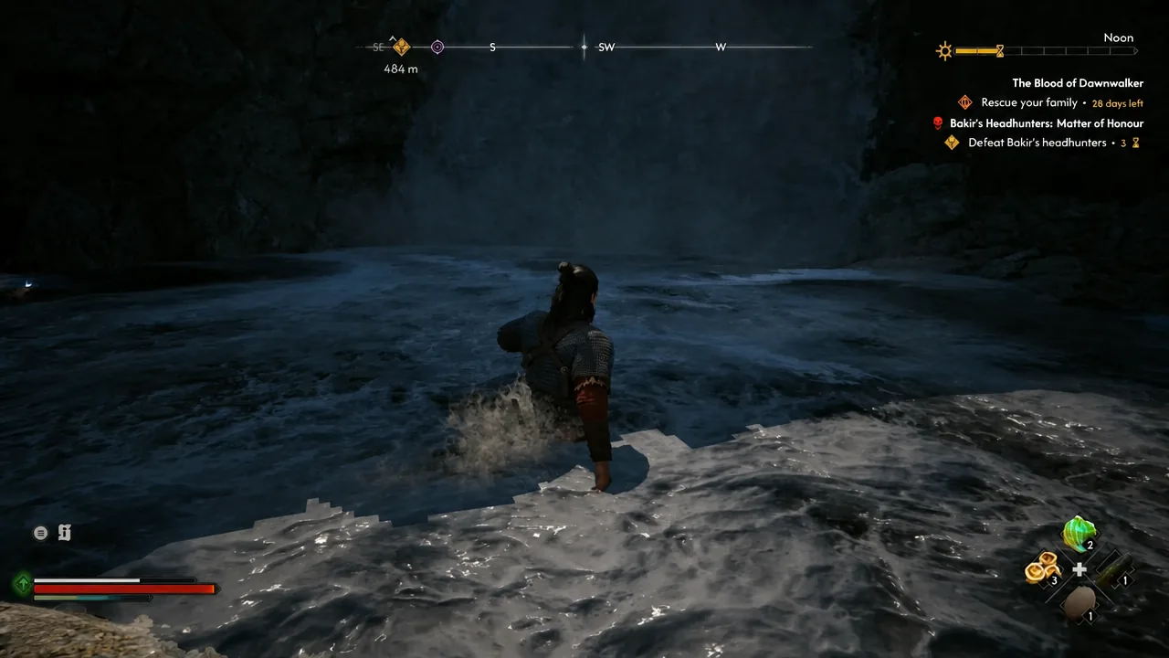 Coen wading through the river toward the hidden cave entrance behind the falls