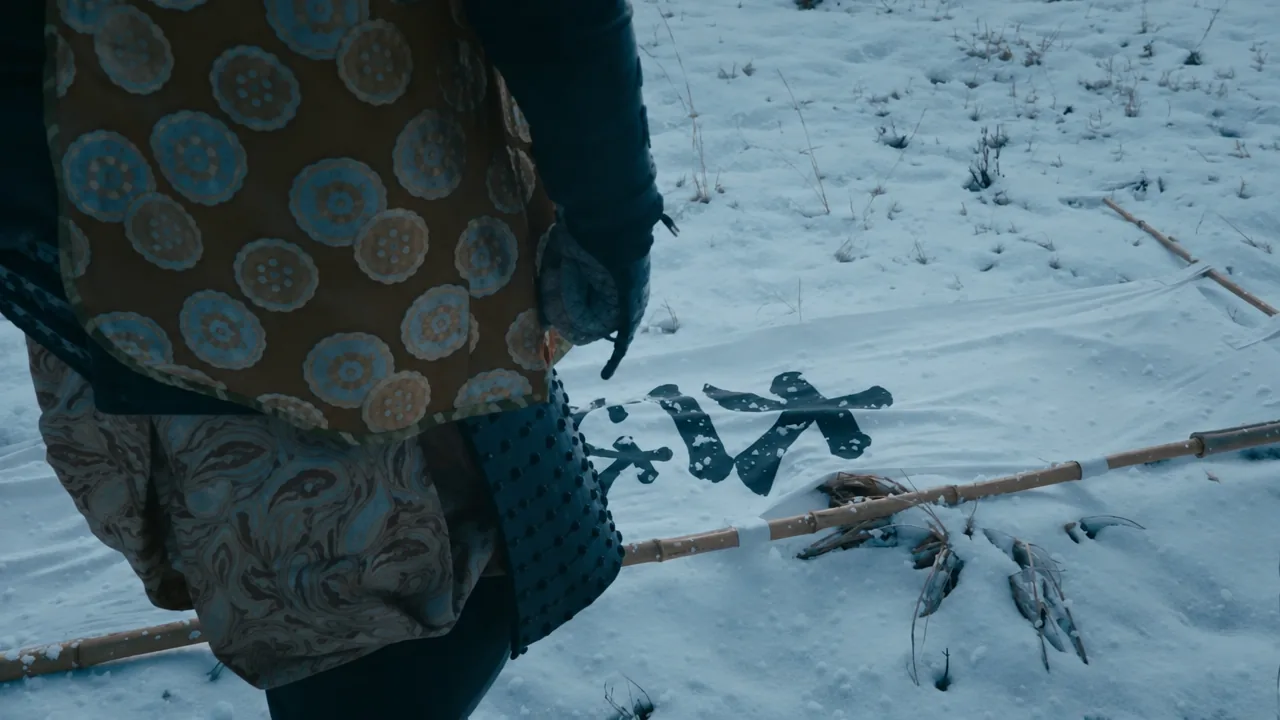 The victorious commander stepping across a fallen clan banner lying in the snow