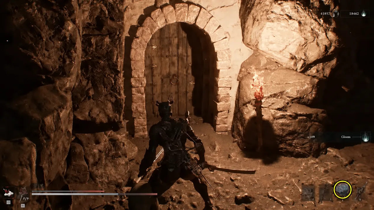 Player approaching the wooden door in a cave, with the ability icon lit at the bottom right
