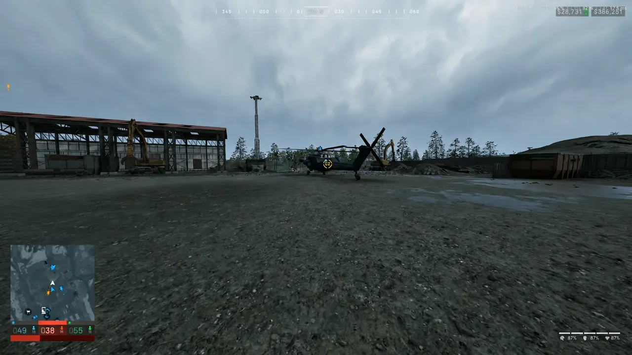 Yellow objective marker over a helicopter in an industrial yard as the player walks toward it