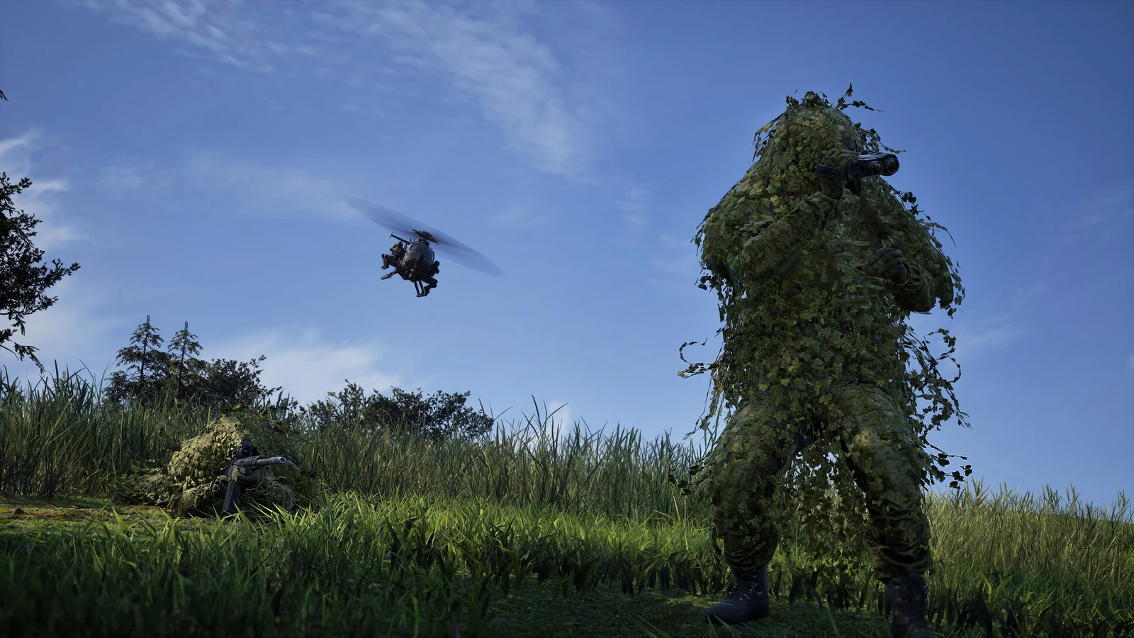 A camouflaged soldier stands in tall grass while a helicopter flies overhead beneath a bright daytime sky.