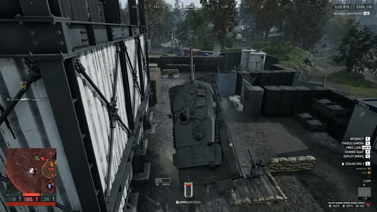 Player driving an armored vehicle past a building in WARDOGS with the Interact prompt on screen